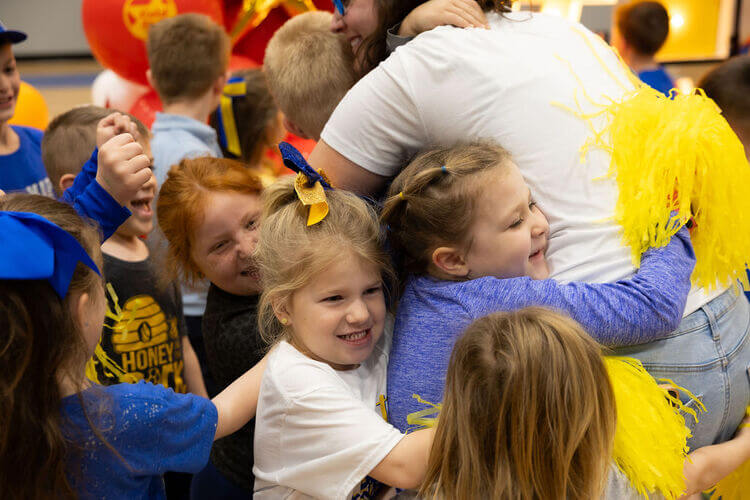 School childen hugging a teacher